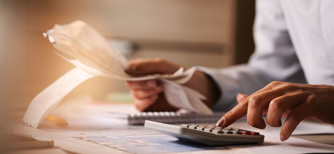Close-up of business accountant using calculator while working i
